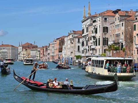 Tourists taking a Gondola ride across the Grand Canal in Venice. 