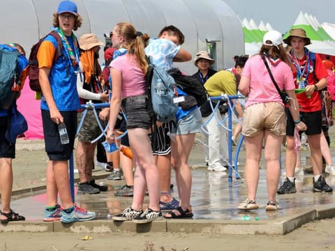 Attendees of the World Scout Jamboree cool off with water at a scout camping site in Buan, South Korea, Friday, Aug. 4, 2023. More than 100 people were treated for heat-related illnesses at the World Scout Jamboree being held in South Korea, which is having one of its hottest summers in years.  