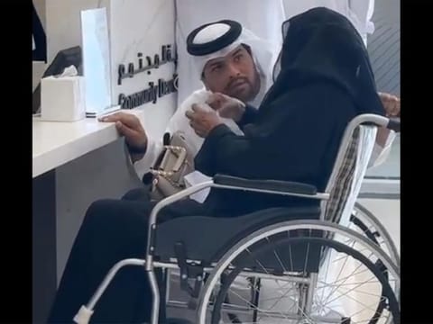  Screen grab of a video showing Jamal Abdulrahman, an Emirati official at the Community Development Authority in Dubai, kneeling down to serve an elderly woman in Dubai.