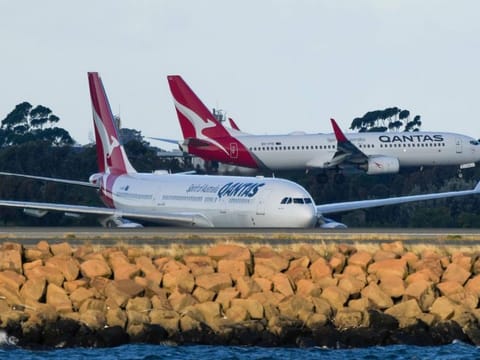 FILE - Qantas passenger jets cross as they taxi at Sydney Airport in Sydney, Australia, on Sept. 5, 2022. Australia’s consumer watchdog on Friday, Sept. 1, 2023, called for Qantas Airways to be punished with a record fine for allegedly selling tickets on thousands of flights that had already been canceled. (AP Photo/Mark Baker,File)