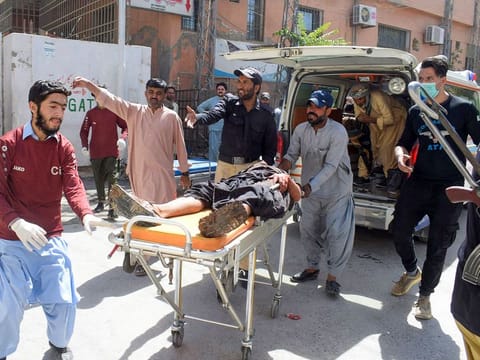 Volunteers carry a blast victim on a stretcher at a hospital in Quetta on September 29, 2023, after a suicide bombing in Mastung district. 