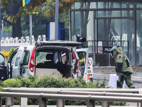 A bomb disposal expert works next to a car after an explosion in Ankara.