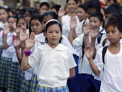 Filipino gradeschool students take an oath of loyalty to the flag and country before the start of classes at a Manila school. For illustrative purposes only.
