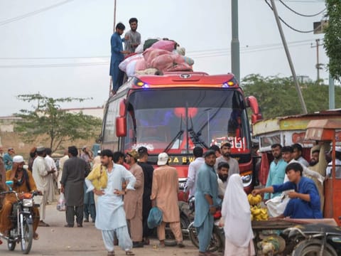 In this photo taken on September 21, 2023, Afghan refugees board a bus from Karachi to Afghanistan.  