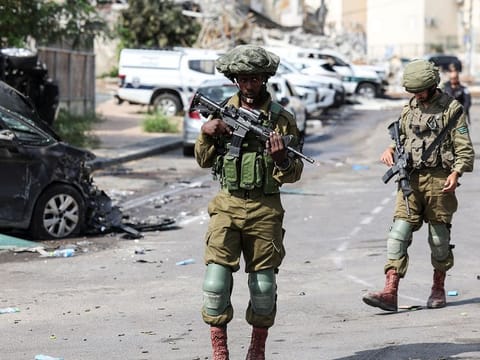 Israeli soldiers patrol near a police station which was the site of a battle following a mass infiltration by Hamas gunmen from the Gaza Strip, in Sderot, southern Israel.