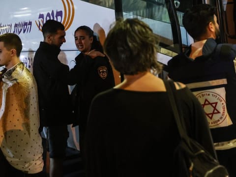 Residents of the southern Israeli city of Netivot bordering the Gaza Strip wait near a bus before being evacuated to central Israel on October 7, 2023.  
