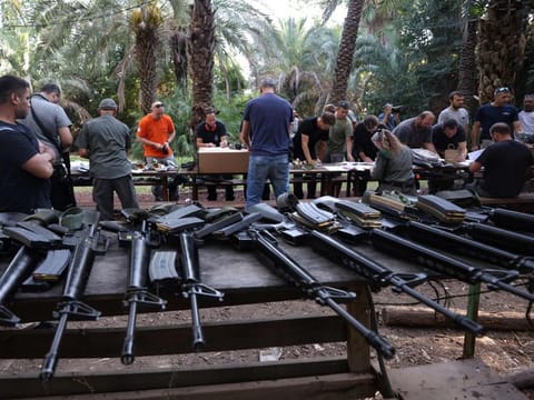 Israelis arrive at a weapons distribution point for people allowed to carry arms, at the Ayyelet HaShahar Kibbutz, in northern Israel, near the Lebanese border on October 12, 2023.  