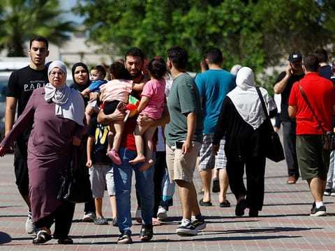 Families of staff of international organisations shelter at a United Nations centre after UNRWA said it relocated its central operations centre to the south of Gaza Strip after Israel's call for more than 1 million civilians in northern Gaza to move south within 24 hours, amid the Israeli-Palestinian conflict, in Khan Younis in the southern Gaza Strip October 13, 2023.  