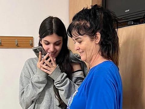 This handout picture courtesy of the United States embassy in Jerusalem taken on October 20, 2023 shows Natalie Shoshana Raanan (L) and Judith Tai Raanan speaking on the phone with US President Joe Biden, after being held hostage and later released by Hamas. 