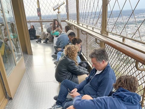 Visitors stranded at the top of the Eiffel Tower while police and firefighters dealt with a man climbing on the structure wait for the lifts to reopen, in Paris, on Thursday. 