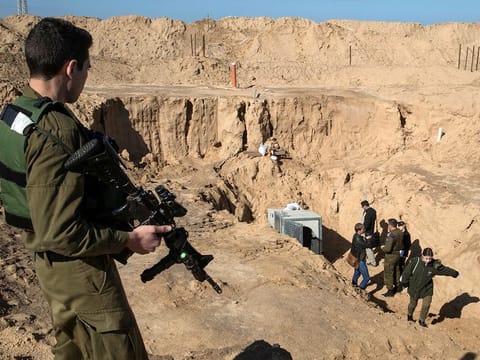 An Israeli soldier keeps guard next to an entrance to what the Israeli military say is a cross-border attack tunnel dug from Gaza to Israel, on the Israeli side of the Gaza Strip border near Kissufim  January 18, 2018. 