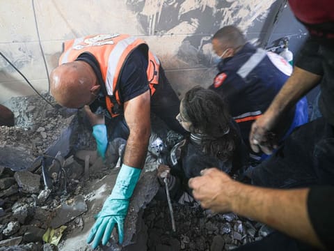 Palestinian rescuers help a victim of Israeli bombardment in Khan Younis in the southern Gaza Strip on November 7, 2023.