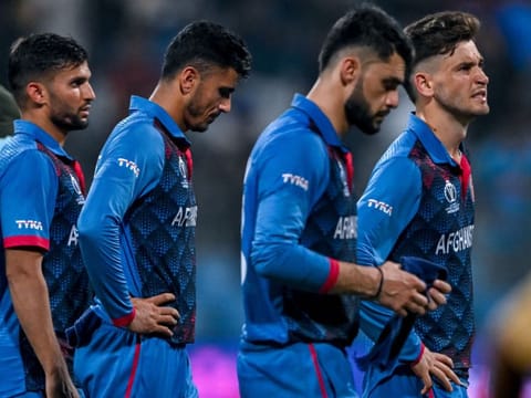 Afghanistan players wear a dejected look after losing their World Cup match against Australia.