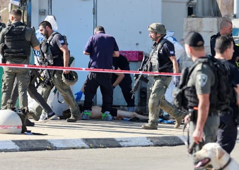Israeli security personnel work near the body of a suspected Palestinian assailant, in the aftermath of a violent incident near Jerusalem, November 16, 2023.  