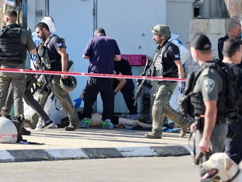 Israeli security personnel work near the body of a suspected Palestinian assailant, in the aftermath of a violent incident near Jerusalem, November 16, 2023.  