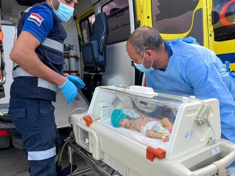 Egyptian medics wheel a premature Palestinian baby evacuated from Gaza to an ambulance on the Egyptian side of the Rafah border crossing with the Gaza Strip, on November 20, 2023.