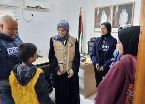 Qatari Minister of State for International Cooperation at the Ministry of Foreign Affairs Lolwah Bint Rashid Al Khater talks to a Palestinian boy at an unidentified location, as she visits Gaza during a temporary truce between Hamas and Israel, November 26, 2023. 