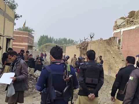 Security officials examine the damage on the site of a bombing at a police station on the outskirts of Dera Ismail Khan on December 12, 2023.  