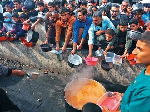 Photos: Hundreds queue up for food in central Gaza 