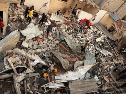 Palestinians inspect a destroyed house after Israeli airstrikes in Rafah, in the southern Gaza Strip on December 20, 2023, amid continuing battles between Israel and the Palestinian militant group Hamas.  