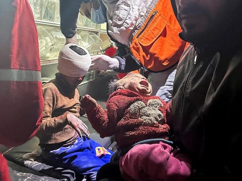 Palestinian girl Mariam Abu Akel and her brother Hamed, who were rescued from under the rubble of a house hit by an Israeli strike, receive medical attention inside an ambulance, in Rafah in the southern Gaza Strip, on December 29, 2023. 