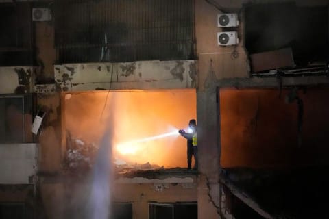 Civil defence workers search for survivors inside an apartment following a massive explosion in the southern suburb of Beirut, on January 2, 2024.  