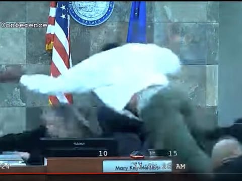 In this image from video provided by the Clark County District Court, a defendant identified by court officials and records as Deobra Redden is seen launching over the desk of Judge Mary Kay Holthus during his sentencing in a felony battery case on Wednesday, January 3, 2024 in Las Vegas. 