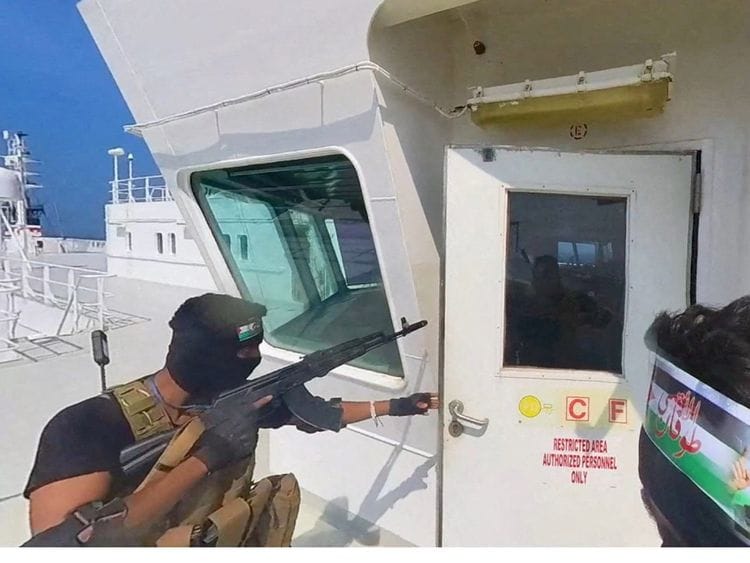 Al Houthi militants open the door of the cockpit on the ship's deck in the Red Sea on November 20, 2023.