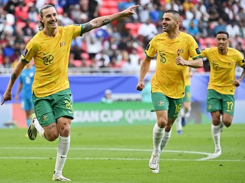 Australia's midfielder Jackson Irvine (left) celebrates with teammates after scoring his team's first goal during the AFC Asian Cup Group B football match against India at the Ahmad bin Ali Stadium in Al-Rayyan, west of Doha on January 13, 2024.  