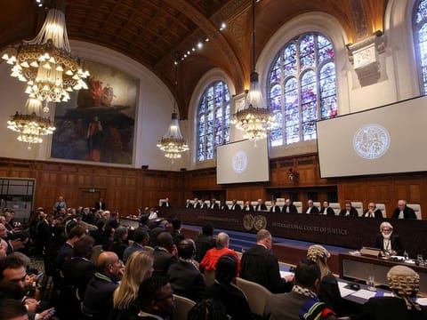 People sit inside the International Court of Justice (ICJ) on the day of the trial to hear a request for emergency measures by South Africa, who asked the court to order Israel to stop its military actions in Gaza and to desist from what South Africa says are genocidal acts committed against Palestinians during the war with Hamas in Gaza, in The Hague, Netherlands, January 11, 2024. 