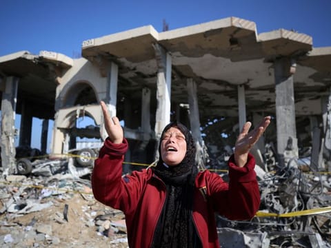 A Palestinian in front of a destroyed building in the Al Maghazi refugee camp in central Gaza Strip, on January 16, 2024 amid oingoing battles between Israel and the Palestinian group Hamas.  