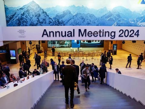 Participants use a staircase under signage which reads "Annual Meeting 2024" at the World Economic Forum (WEF) meeting in Davos on January 17, 2024. 
