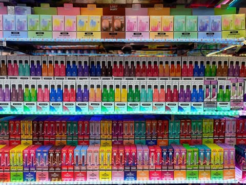 A selection of colourful disposable vapes on display for sale in a shop in London.