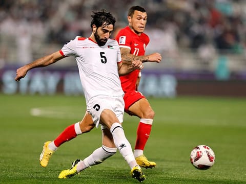 Palestine's Mohammed Saleh in action with Hong Kong's Everton Camargo 