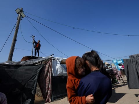 Displaced Palestinian teenager Hussam Al Attar, nicknamed by people 'Newton', works on wind turbines, that he uses to light up his shelter during power cut, at a tent camp in Rafah, in the southern Gaza Strip, February 6, 2024.  