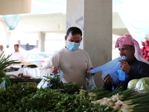 A man buys vegetables at a market in Qatif, Saudi Arabia. Jeddah wholesale market is full of expatriates unlawfully involved in business deals.