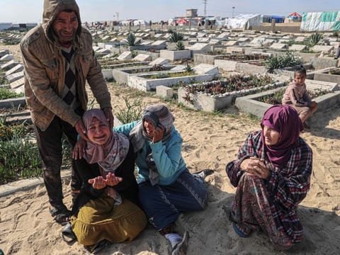 Relatives mourn during the funeral of loved ones killed during overnight Israeli strikes at a cemetery in Rafah, on the southern Gaza Strip on February 21, 2024, amid ongoing battles between Israel and the militant Hamas movement.  