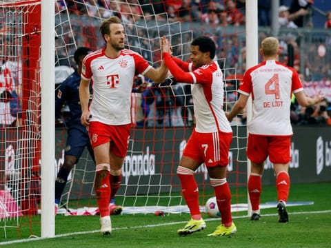 Bayern Munich's Harry Kane celebrates scoring their seventh goal to complete his hat-trick with Serge Gnabry during a Bundesliga match against FSV Mainz 05.