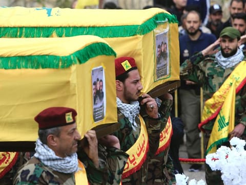 Hezbollah militants and supporters attend the funeral of one of the group's members Hassan Hussein, his wife Ruwaida Mustafa, and their 25-year-old son Ali Hussein, killed in Israeli bombardment, during their funeral in their southern Lebanese village of Houla on March 6, 2024.