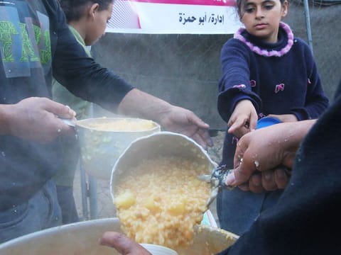 A street kitchen distributes free food handouts to displaced Palestinian children in Deir al-Balah, central Gaza, on Wednesday, March 13, 2024. 