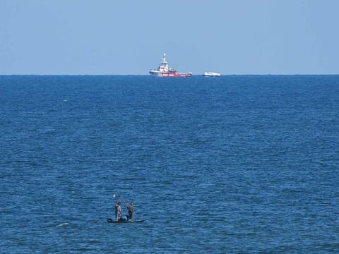 A ship belonging to the Open Arms aid group approaches the shores of Gaza towing a barge with 200 tons of humanitarian aid on Friday, March 15, 2024. 