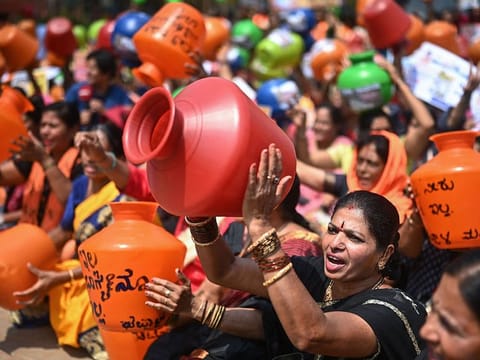 Activists hold empty water pots as they shout slogans during a protest against the state government over ongoing severe water crisis, in Bengaluru on March 12, 2024. 