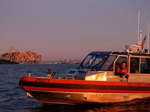 A US Coast Guard vessel secures the perimeter, after the Dali cargo vessel crashed into the Francis Scott Key Bridge causing it to collapse in Baltimore, Maryland,