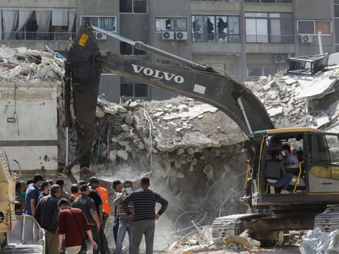 Rescue workers search in the rubble of a building annexed to the Iranian embassy a day after an air strike in Damascus on April 2, 2024.  