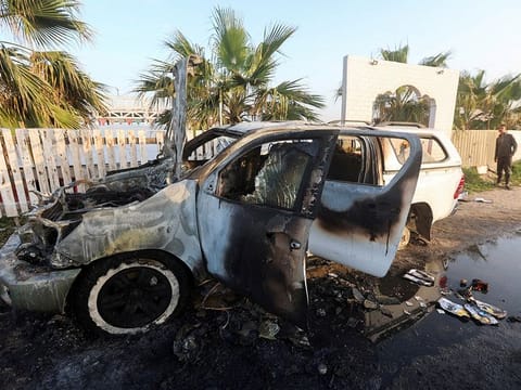 A person looks at a vehicle where employees from the World Central Kitchen (WCK), including foreigners, were killed in an Israeli airstrike. 