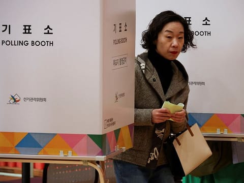 A woman walks at a polling station during the 22nd parliamentary election in Seoul, South Korea, April 10, 2024. 