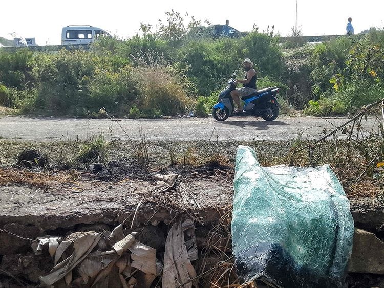 A motorist rides a motorcycle past the site of an Israeli strike