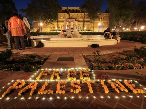 People stand near a flower arrangement that reads "Free Palestine" during a protest in support of Palestinians in Gaza at the University of Southern California (USC) in Los Angeles on April 27, 2024.  