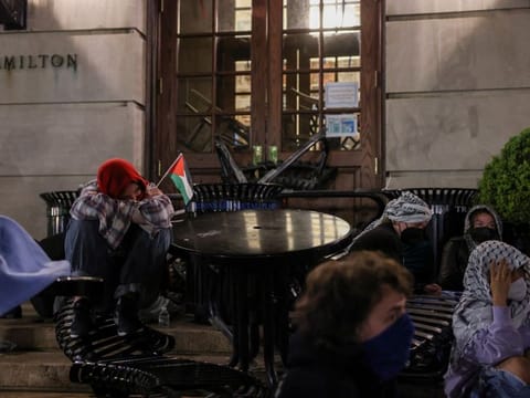 Student protesters sit watch outside Hamilton Hall, where students at Columbia University continue protesting in support of Palestinians barricaded themselves inside the building.