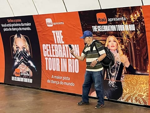 A man poses for a selfie with an ad for a mega-free concert by US pop star Madonna displayed at a metro station in the Copacabana neighbourhood of Rio de Janeiro, Brazil, on April 30, 2024. The singer will perform on May 4 on Rio de Janeiro's Copacabana beach to close her 'Celebration' tour.  